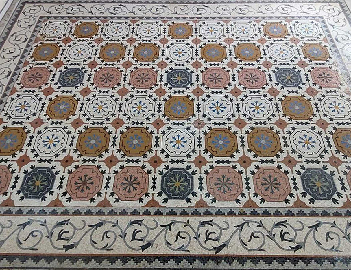 Macro photograph highlighting the artisanal hand-cut stone tesserae and seamless interlocking seams of the mosaic rug.