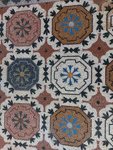 Luxury entry floor inlay showcasing the rich natural colors of terracotta, rose, and gold marble mosaic tiles.