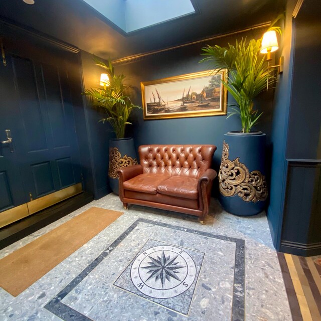 Luxury foyer entryway featuring a custom handcrafted square nautical compass rose mesh-backed marble mosaic medallion tile sheet installed on the floor.