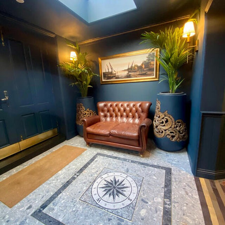 Luxury foyer entryway featuring a custom handcrafted square nautical compass rose mesh-backed marble mosaic medallion tile sheet installed on the floor.