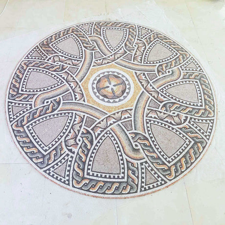 Perspective angle view of a hand-cut earth tone geometric marble mosaic medallion on mesh backing before installation.